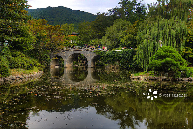 人们在池塘上的桥上行走图片素材