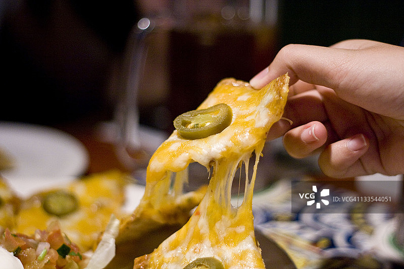 在餐厅手持美味的芝士玉米片图片素材