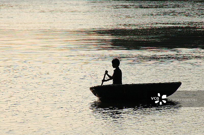 日落时划船的男孩图片素材