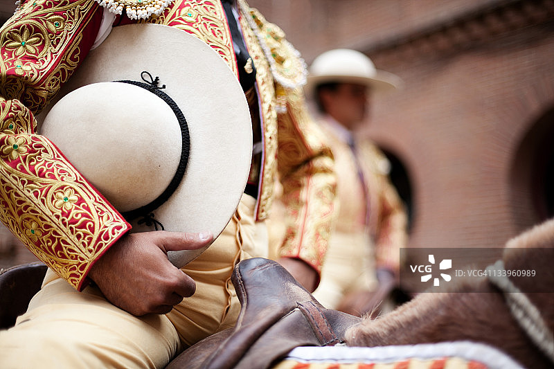 骑着斗牛士拿着帽子的马图片素材