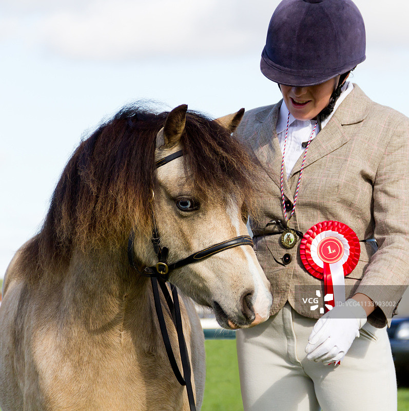 获胜！年轻骑手和她的小马庆祝获得一等奖。图片素材
