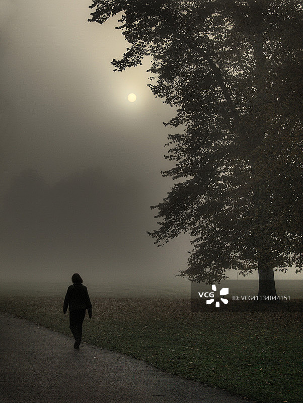 在晨雾中行走的女人图片素材