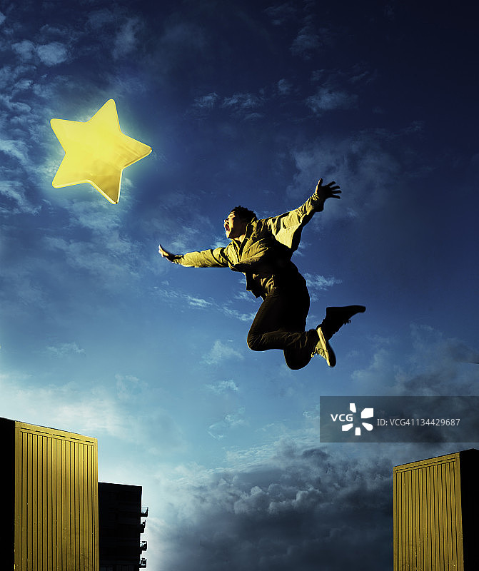 跳跃捕捉星形游戏图标的年轻男子图片素材