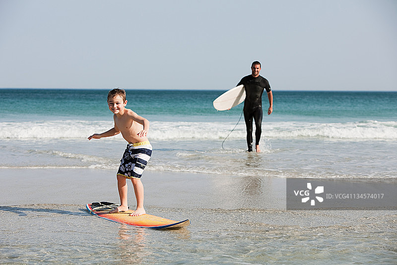 在浅水中冲浪的男孩图片素材