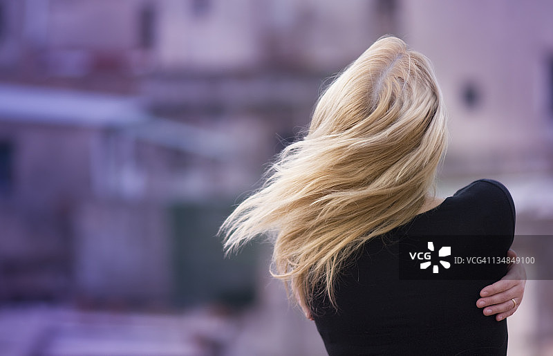 在风中拥抱自己的女孩图片素材