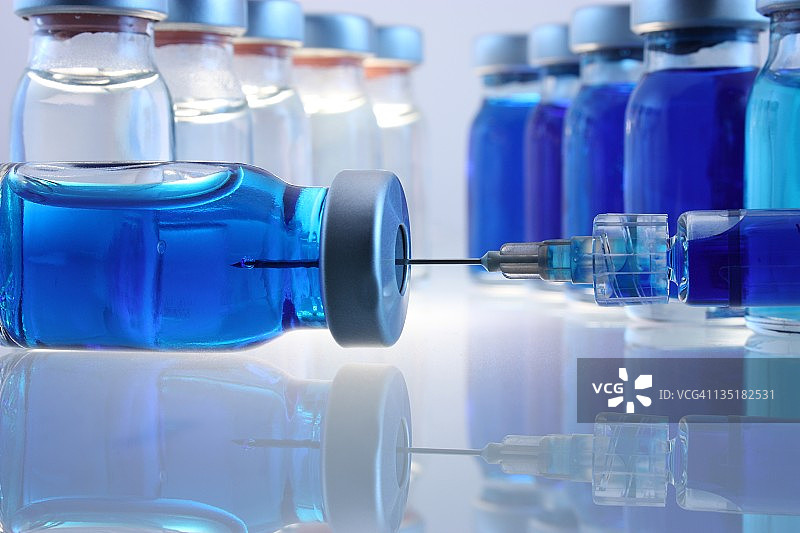 装有蓝色物质和注射器的实验瓶图片素材