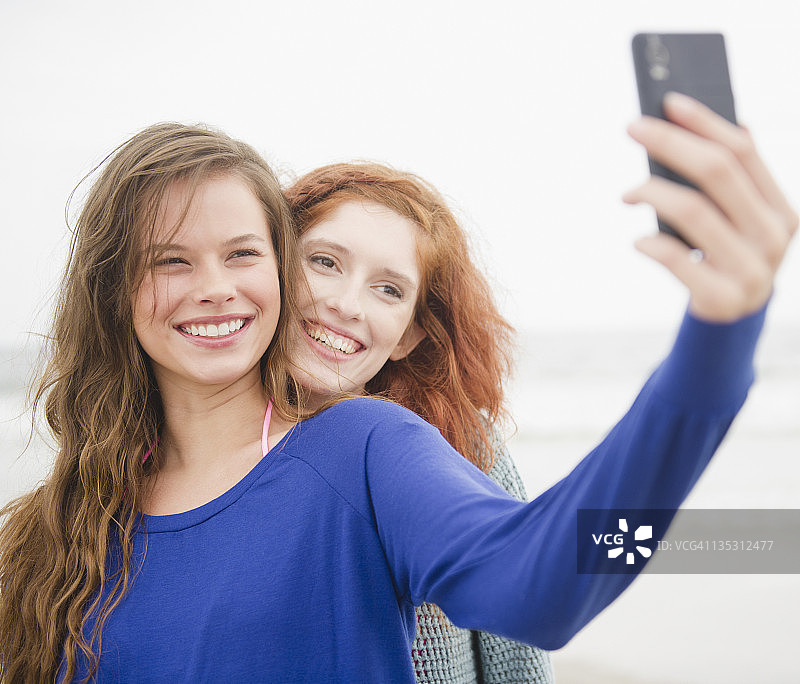 朋友们在海滩用手机自拍图片素材