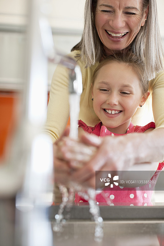 奶奶帮助孙女洗手图片素材