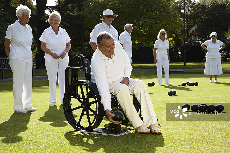 坐在轮椅上打保龄球的男士图片素材