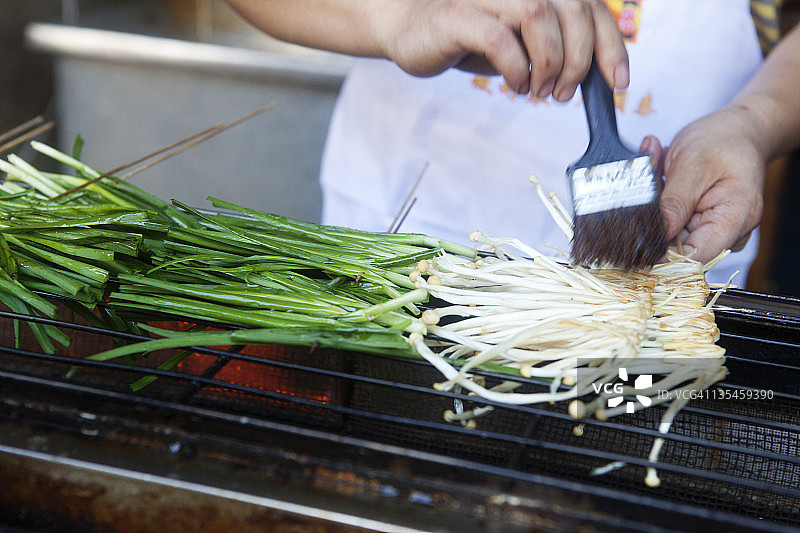 烤架上刷酱的绿洋葱图片素材
