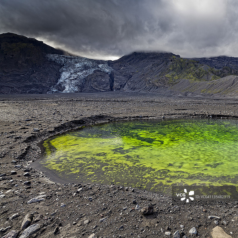池塘中的藻类，背景是吉格约库尔冰川图片素材