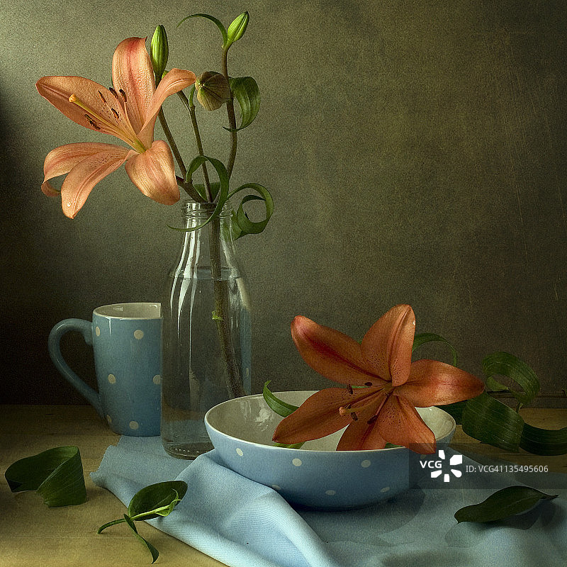 橙色百合花和蓝色波点杯子图片素材