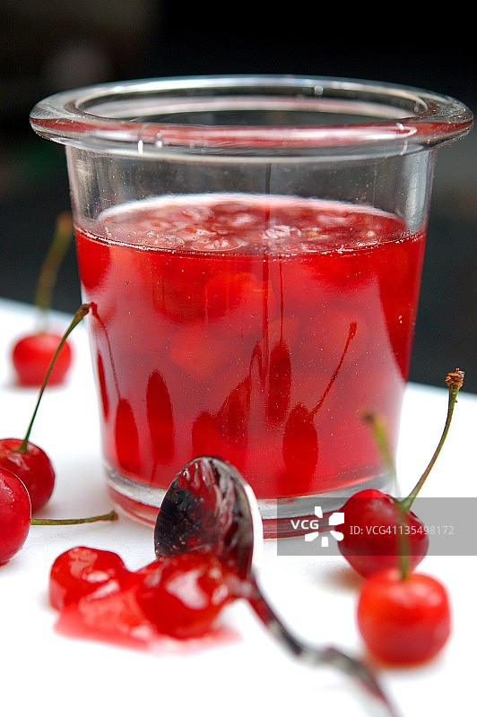 勺子和红色樱桃果酱罐图片素材