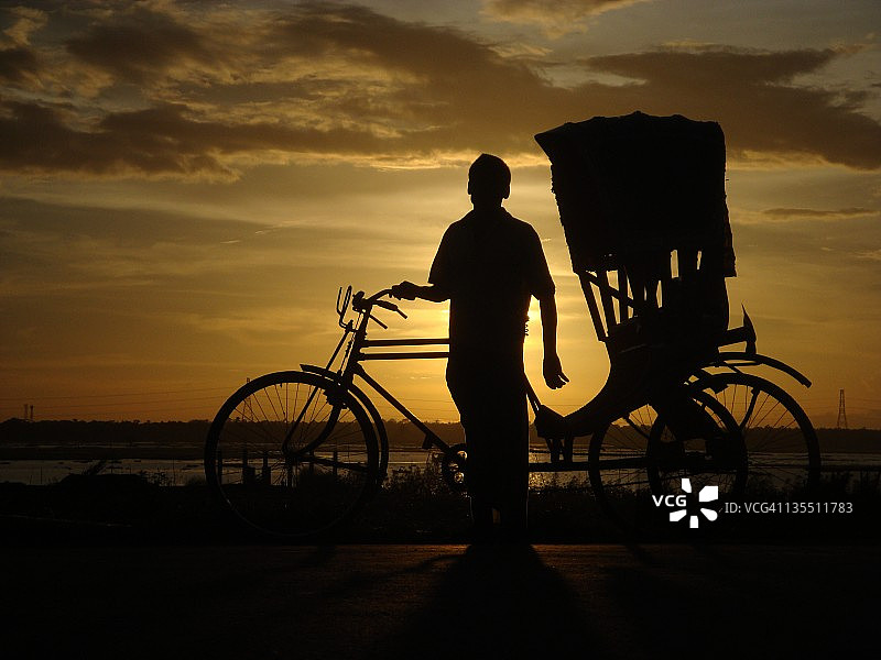 日落时骑自行车的男子剪影图片素材