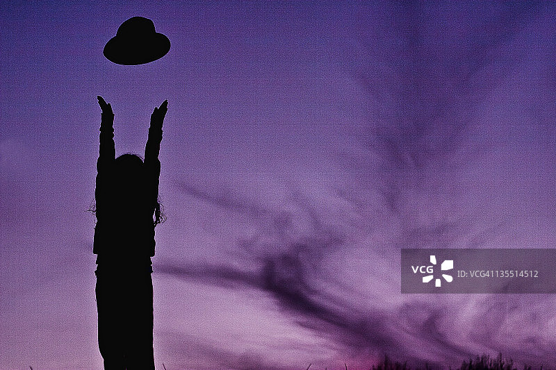 空中抛帽子的女孩剪影图片素材