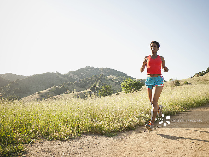 混血女人在偏僻的小路上跑步图片素材