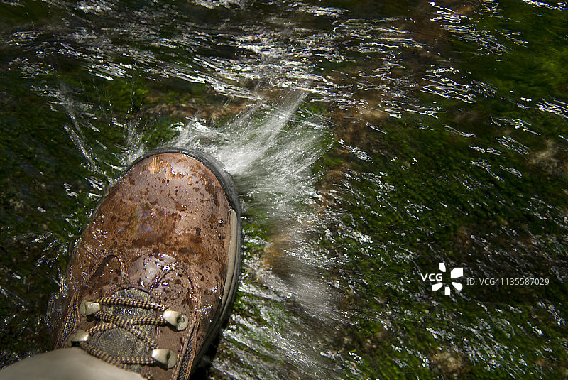 男子在湍急的河流中踩着石头图片素材