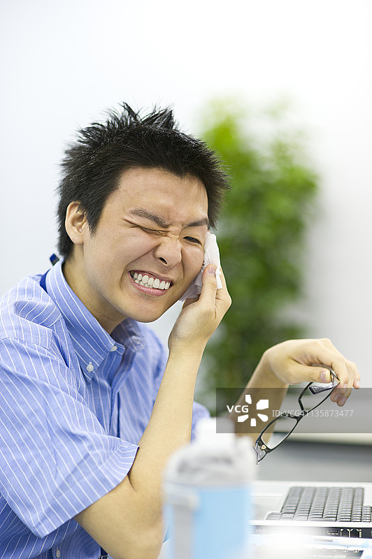 年轻商人用湿巾擦脸图片素材