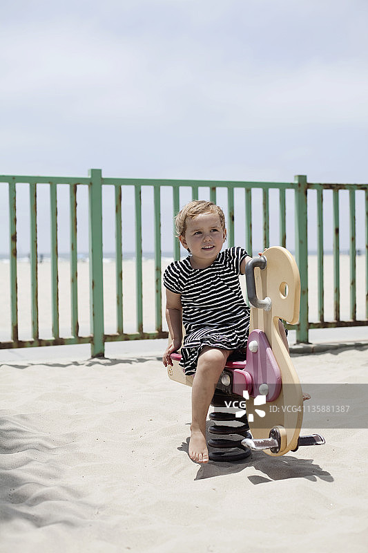 海滩附近游乐场上的一个小孩图片素材