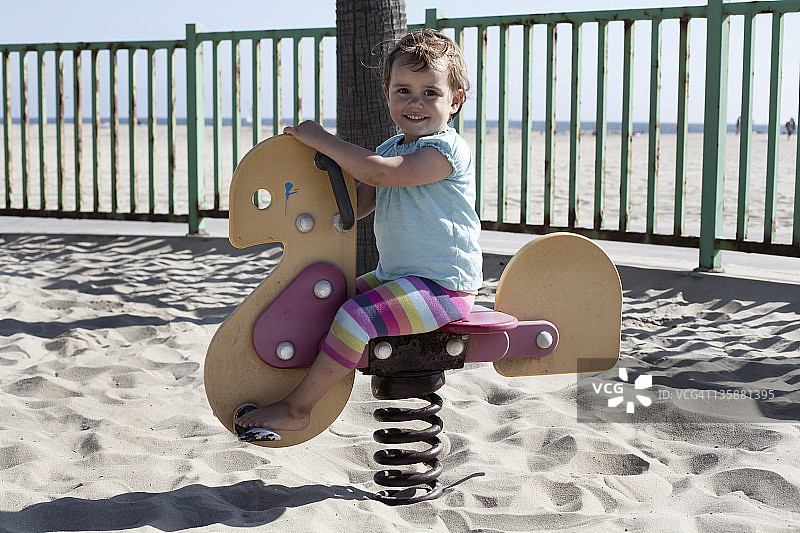 在海滩摇摆的年轻女孩图片素材