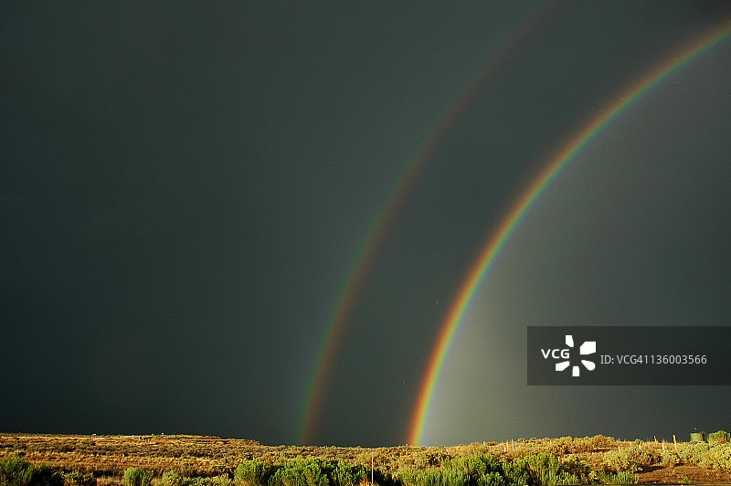 黑暗天空下的双彩虹图片素材