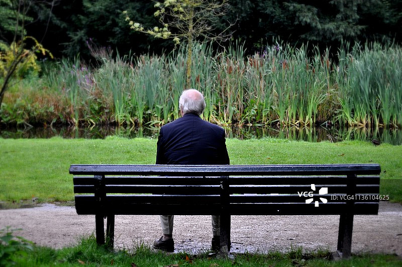 坐在花园长椅上的老年男人图片素材