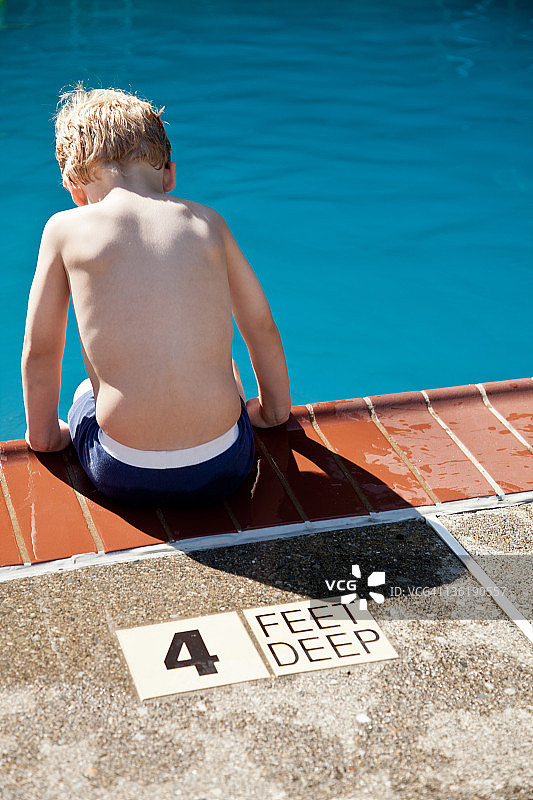 男孩坐在游泳池边沿图片素材