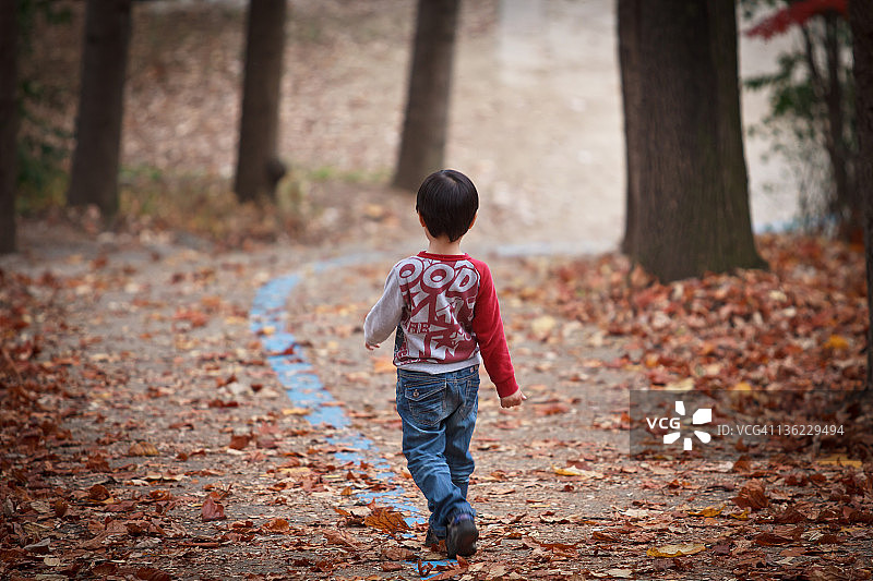 男孩在公园沿着线行走图片素材