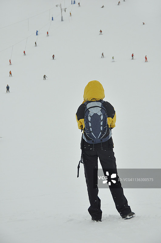 女人看着人们滑雪图片素材