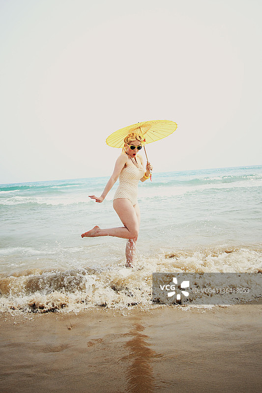 站在海里打伞的女人图片素材