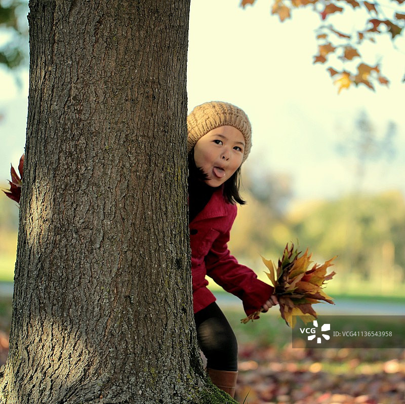 秋天里玩捉迷藏的小女孩图片素材