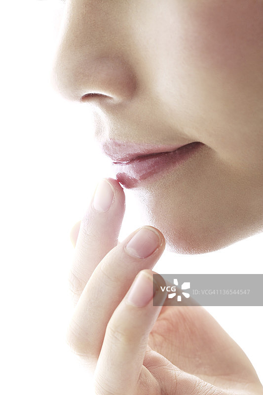 年轻女子涂抹润唇膏图片素材