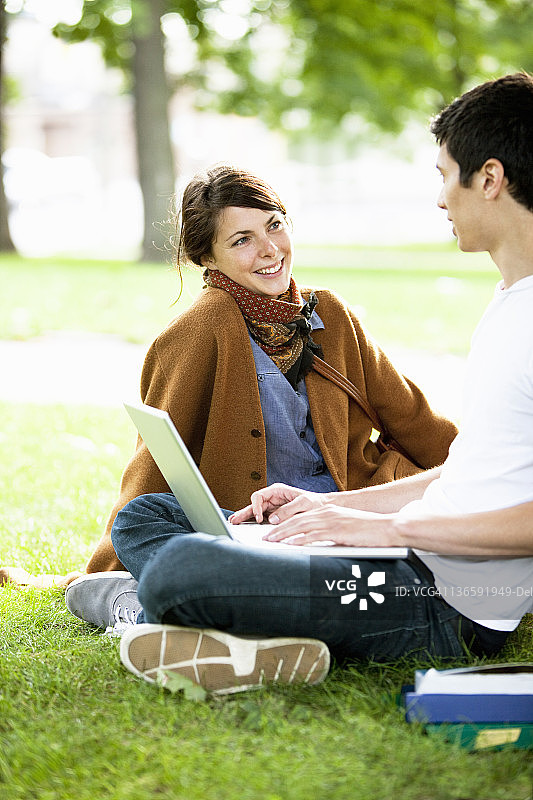 在公园里用笔记本电脑学习的学生图片素材