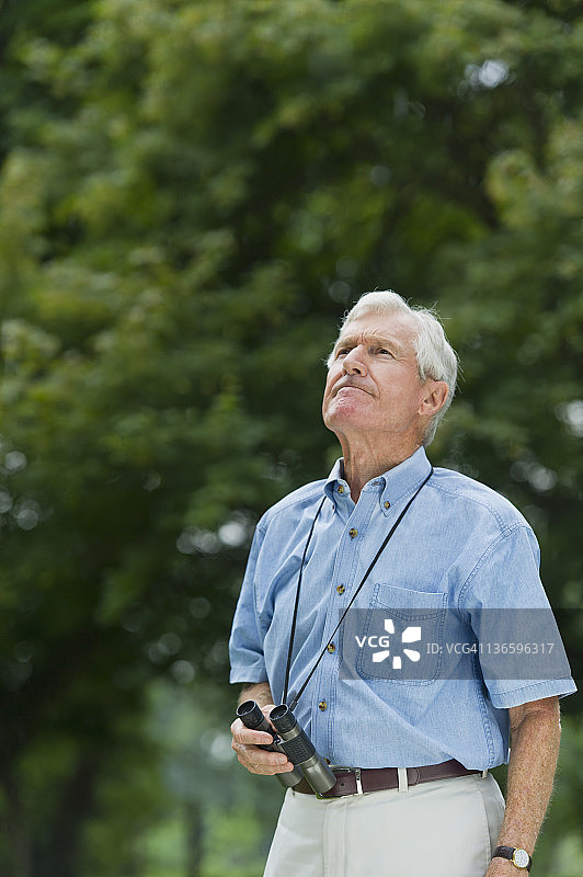 美国纽约州老韦斯特伯里拿着双筒望远镜的老年男人图片素材