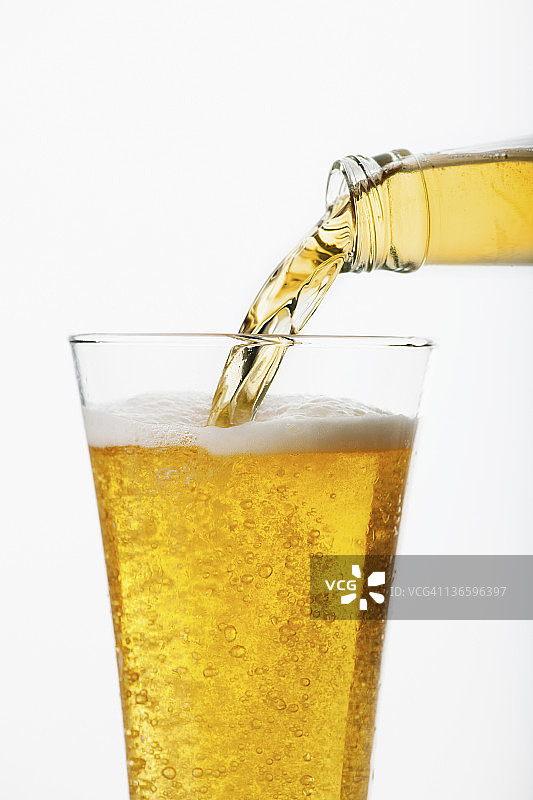 啤酒倒入玻璃杯，影棚拍摄图片素材