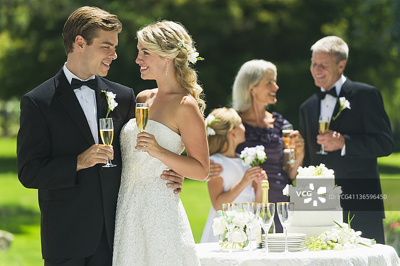 美国纽约州老韦斯特伯里，已婚夫妇举着香槟酒杯，背景是客人图片素材