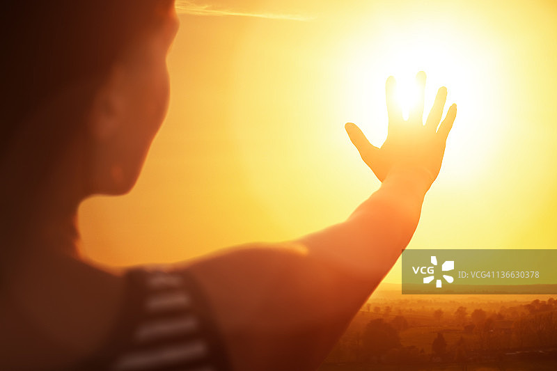 女人伸手向太阳图片素材