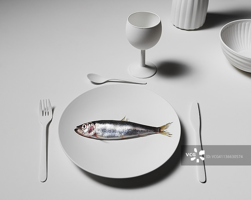 摆放着鲱鱼的白色餐桌图片素材