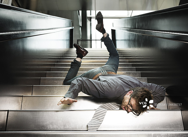 年轻商人从楼梯上摔下来图片素材