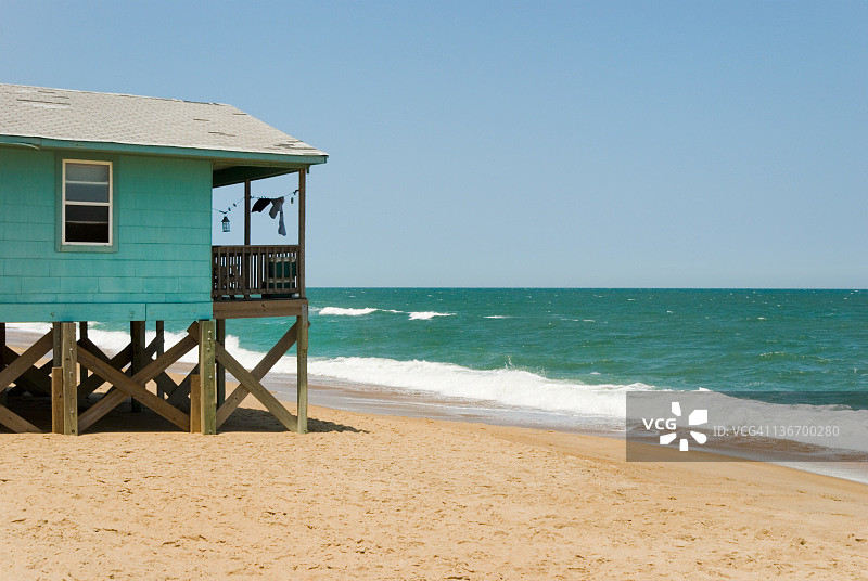 可观海浪和海平线的海边沙滩屋图片素材