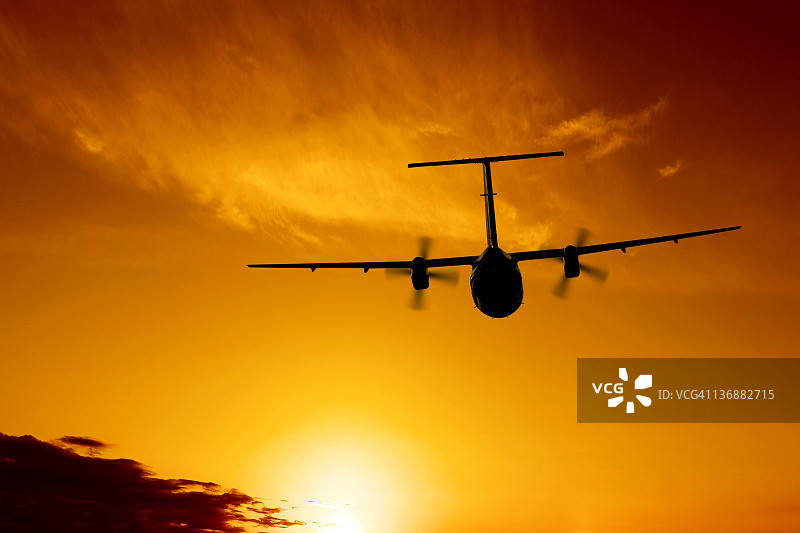 日落时分飞行的螺旋桨飞机图片素材