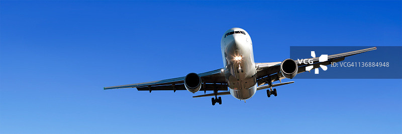 喷气式飞机在蔚蓝天空着陆图片素材