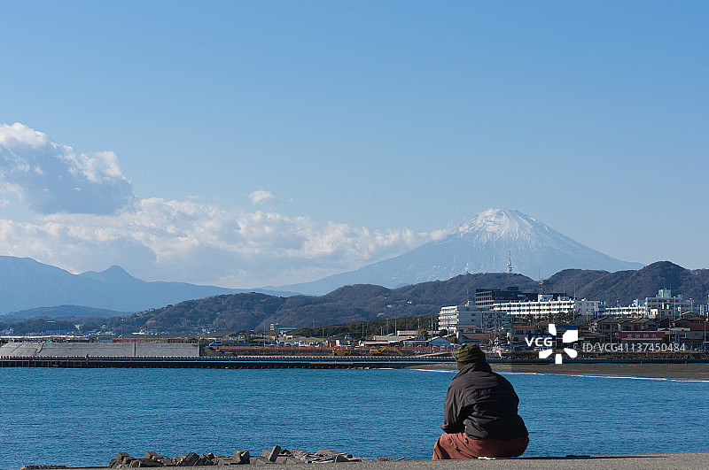 男人坐在海边码头上图片素材