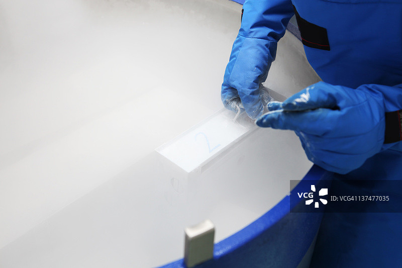 装有液氮的容器…穿着防护服的医生在工作图片素材