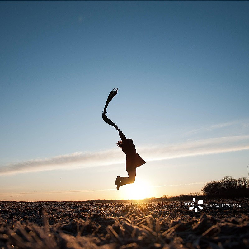 在田野里跳跃的女人的轮廓图片素材