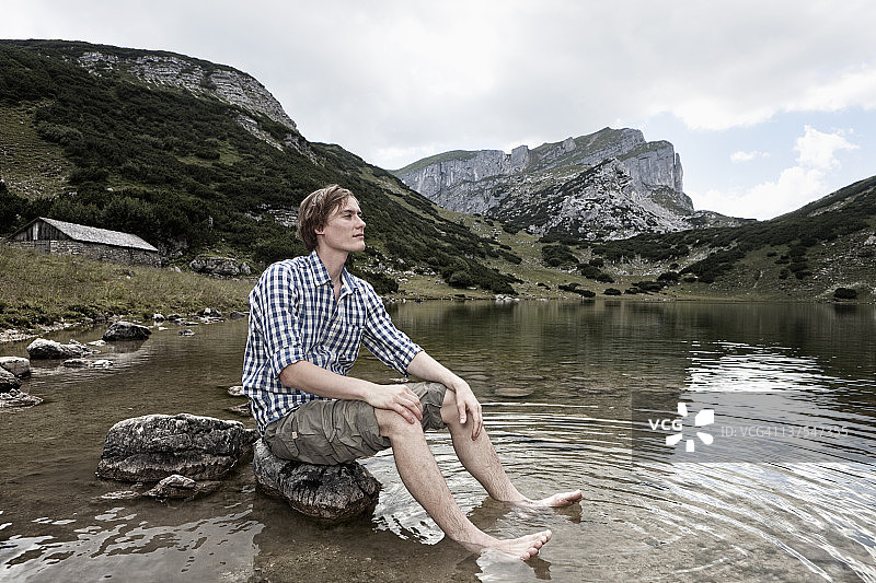 男人在岩石湖中放松图片素材