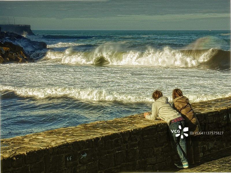 情侣在海浪中观看彩虹图片素材