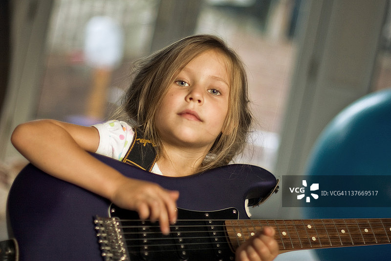 漂亮的金色头发女孩用电吉他摇滚图片素材
