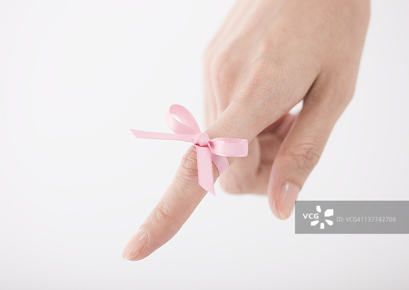 系在女人手指上的粉色丝带图片素材