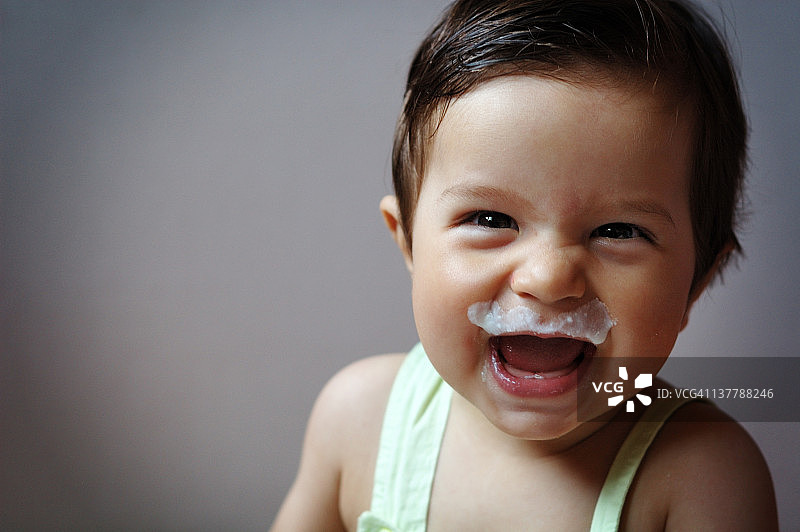 小男孩笑着，嘴唇上有牛奶图片素材
